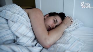 Girl's bare feet in bed