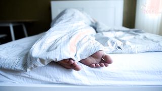 Girl's bare feet in bed