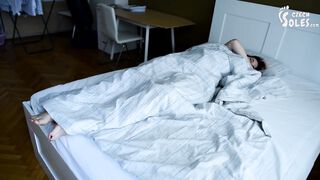 Girl's bare feet in bed